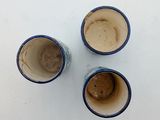 three empty coffee cups sitting on a white surface