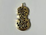 a close up of a gold pendant on a white surface