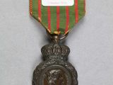 une image représentant une médaille entourée d'un ruban rouge et vert