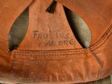 a close up of a brown baseball cap with a name on it