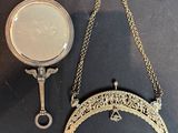 a gold necklace and a mirror on a black table