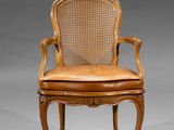a wooden chair with a leather seat and cane back