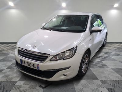 La petite voiture blanche est garée dans le garage, sur le sol à damier.