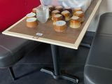 une table sur laquelle sont posées des tasses de café, à côté d'un banc