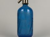 une bouteille en verre bleue munie d'une pompe en métal