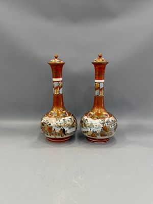 pair of orange and white vases sitting on top of a white table