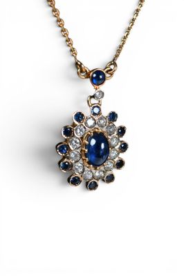 un gros plan d'un pendentif en forme de diamant bleu et blanc monté sur une chaîne en or
