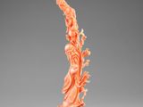 une statue sculptée dans de l'orange représentant une femme, posée sur un socle