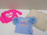 three baby clothes that are on a white table
