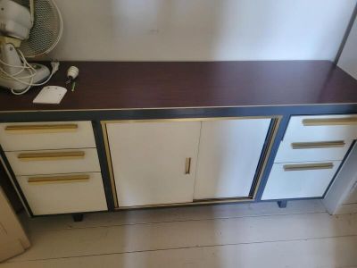 a brown and white cabinet with a fan on top of it