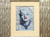 painting of a woman with red lips in a silver frame