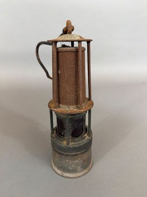 Une cafetière à l'ancienne est posée sur un plan de travail blanc.