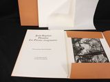 an open book sitting on top of a black table next to a black and white photo