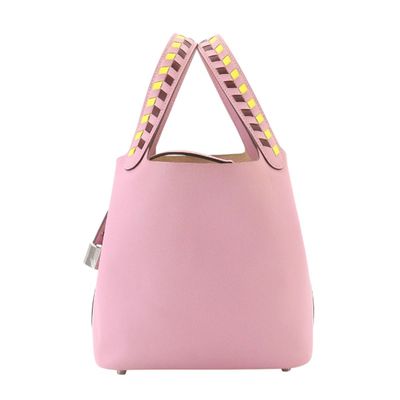 a pink handbag with studded handles on a white background