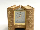 une petite horloge fabriquée à partir de vieux livres, posée sur une table