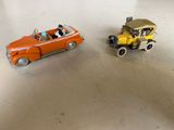 deux petites voitures posées sur une table