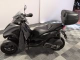 a black motorcycle parked in a room with a checkered floor