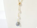 a close up of a necklace with pearls on a mannequin