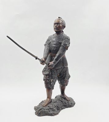 une statue représentant un homme tenant une épée, assis sur un rocher