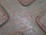 a close up of a rusted metal plate with a cross on it
