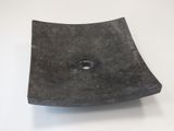 un objet noir de forme carrée, percé d'un trou