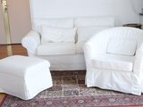 two white chairs and a ottoman in a living room