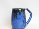 a close up of a blue coffee mug on a white background
