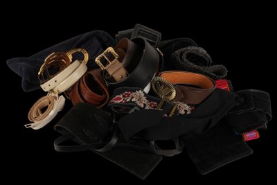a pile of belts and other accessories on a black background