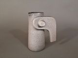 a white vase that has a handle on it