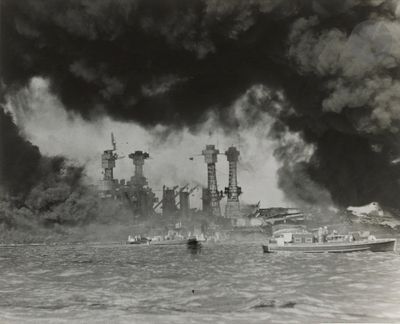 photographie en noir et blanc d'un cuirassé à l'eau, d'où s'échappent des nuages de fumée
