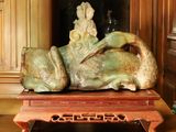 une statue représentant une femme allongée sur une table en bois