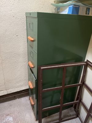 une pile de tiroirs verts dans une pièce, à côté d'une échelle