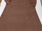 the back of a brown dress sitting on top of a white table