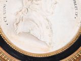 portrait of a man in profile in a gold frame with a black border