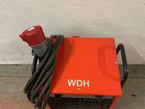 a red blower sitting on top of a cement floor next to a wall
