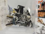 a clear container filled with assorted tools on a table