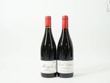 deux bouteilles de vin rouge posées l'une à côté de l'autre sur une surface blanche