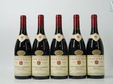 six bouteilles de vin sont alignées sur une surface blanche