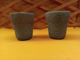 deux vases posés sur une surface jaune