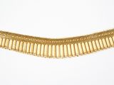 a close up of a gold necklace on a white surface