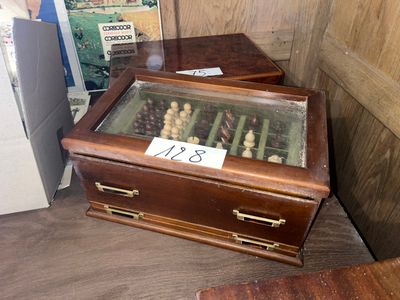 une boîte en bois contenant des pièces d'échecs, posée sur une table