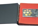 an image of a red binder with coins and a credit card in it