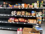 many shelves of food in a grocery store that are empty