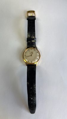une montre posée sur une surface blanche