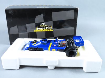 maquette bleu et blanc d'une voiture de course devant un stand