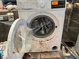 a dirty washing machine sitting on the floor in a room