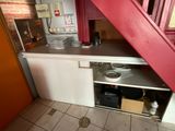 a small kitchen with a red door and a red staircase