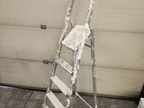 a ladder leaning against a garage door with a sign on it