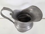 a silver pitcher that is sitting on a table