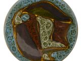 une assiette bleue ornée d'un motif marron et vert